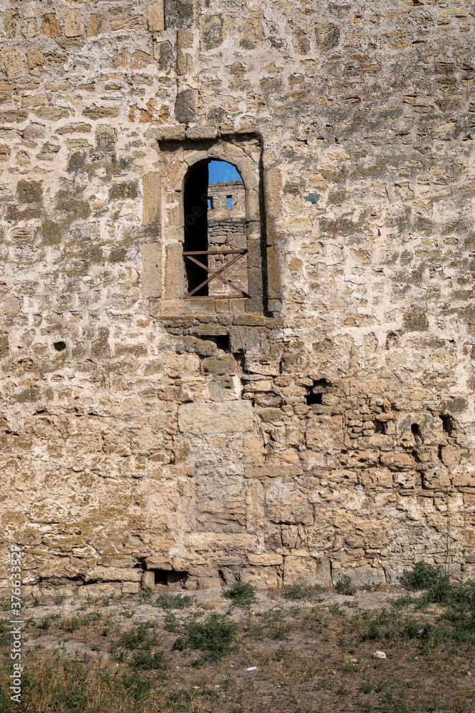 historical loophole lit by the sun in an old castle, vertical