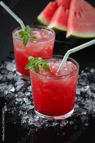 Summer cold drink with watermelon and mint on a black wooden background..