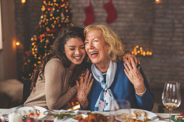 Mother and daughter hugging over Christmas dinner