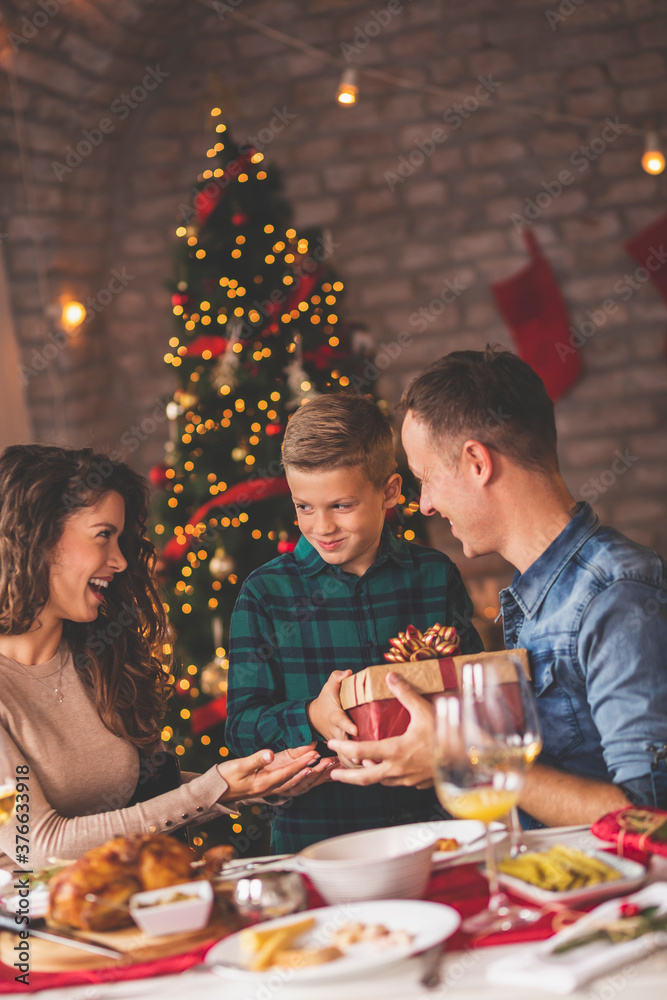 Mother and father giving Christmas present to their son Mother and father giving Christmas present to their son