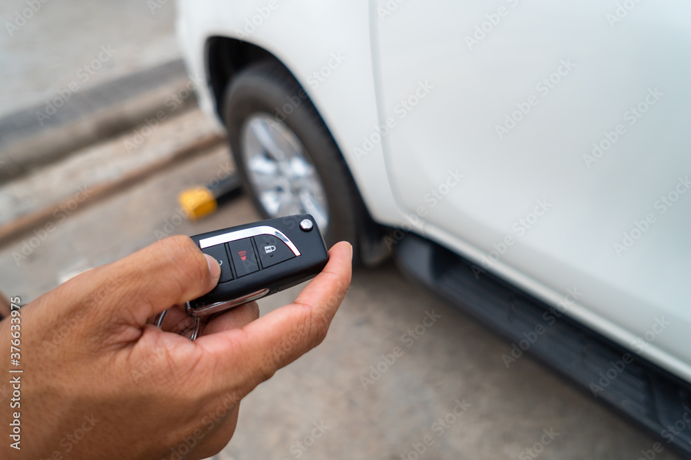 Hand pressing the button on the remote to lock or unlock the car with the remote control. Hand pressing the button on the remote to lock or unlock the car with the remote control.
