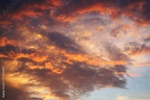 Evening sky in picturesque clouds, illuminated by the rays of the setting sun.