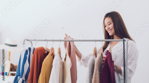 Beautiful asian woman fashion designer standing in the clothing store and studio.Small Business online influencer concept.