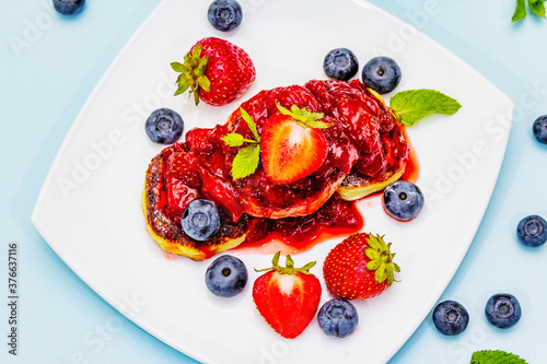 Cottage cheese pancakes with fresh berries and strawberry sauce. Healthy breakfast concept for kids