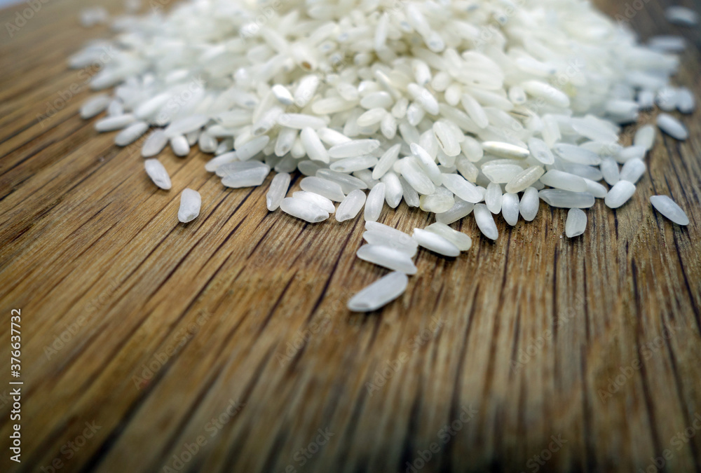 Fototapeta premium White rice on wooden board close-up.