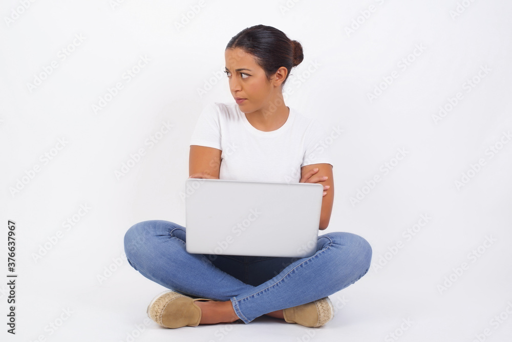 Image of upset pretty young caucasian lady standing indoors with arms crossed. Looking with disappointed expression aside after listening to bad news. Confident girl. Image of upset pretty young caucasian lady standing indoors with arms crossed. Looking with disappointed expression aside after listening to bad news. Confident girl.
