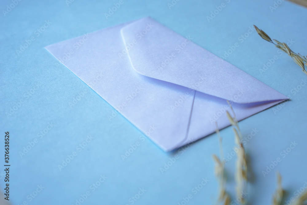 white envelope with dried grass for greeting mockup seasonal concepts on blue background - obrazy, fototapety, plakaty 