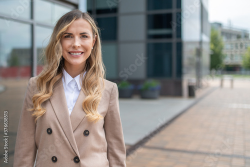 Smiling businesswoman in front of her office