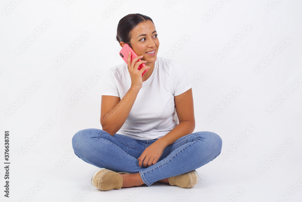 Lifestyle Concept - Portrait of beautiful Caucasian joyful woman talking on mobile phone with friend. Yellow pastel studio background. Copy Space. Lifestyle Concept - Portrait of beautiful Caucasian joyful woman talking on mobile phone with friend. Yellow pastel studio background. Copy Space.