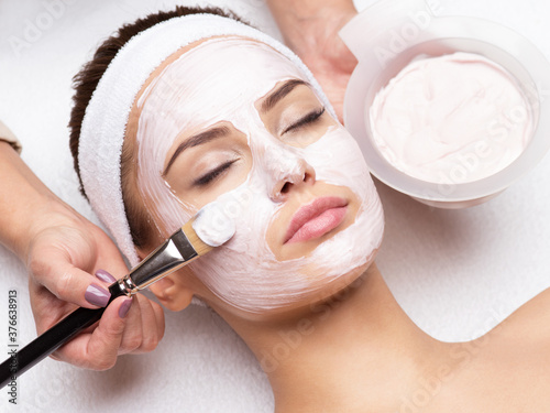 woman receiving facial mask in spa beauty salon