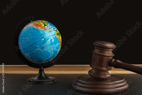 Wooden Judge gavel and globe. International Environment law. Law and justice court concept.