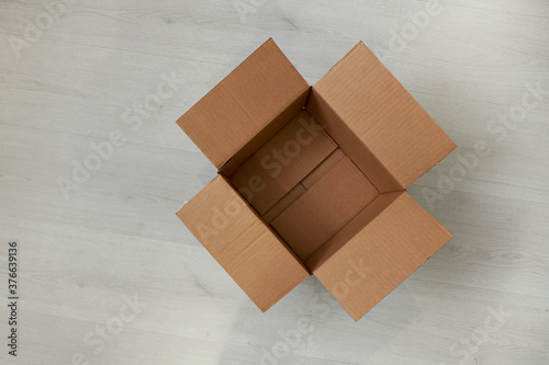 Flat lay of empty open cardboard box on wooden surface