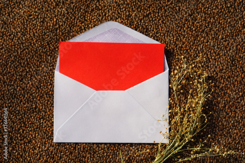 white envelope and red letter with dried grass for greeting mockup seasonal concepts on wool fabric background
