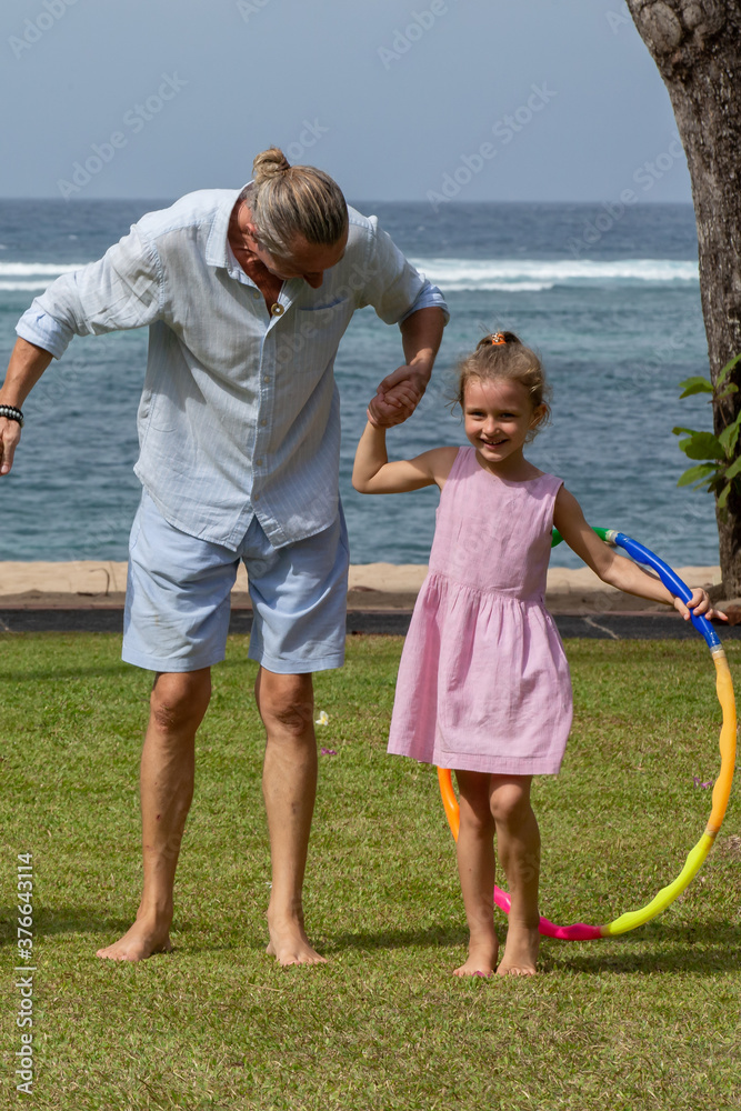 Family, parenthood, fatherhood and people concept - happy father and little girl having fun by the sea during summer vacation Family, parenthood, fatherhood and people concept - happy father and little girl having fun by the sea during summer vacation