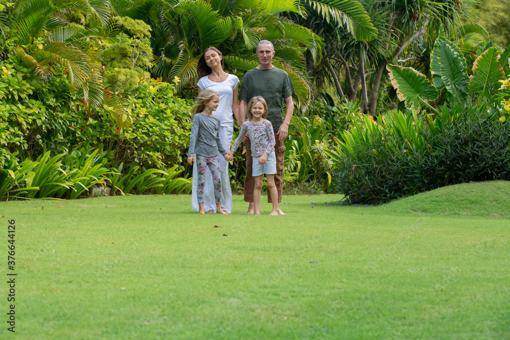 Young happy family walking in tropical park or gaden with palm trees. Summer exotic vacation Young happy family walking in tropical park or gaden with palm trees. Summer exotic vacation