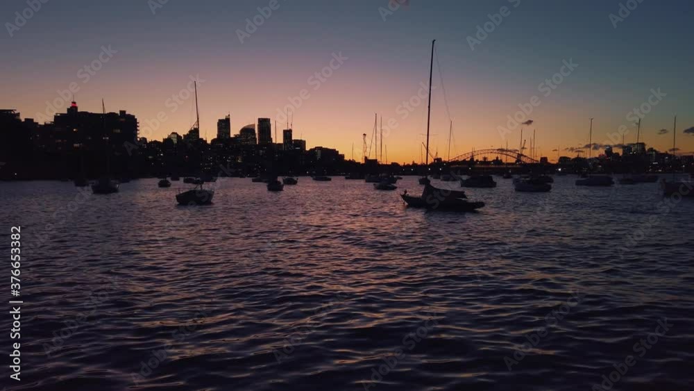 Colorful glow from last light of day in Sydney harbor with silhouette boats Colorful glow from last light of day in Sydney harbor with silhouette boats