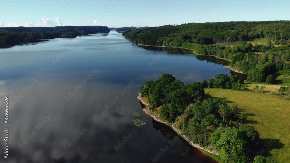 Aerial view of beautiful blue lake surrounded by green land and trees Aerial view of beautiful blue lake surrounded by green land and trees