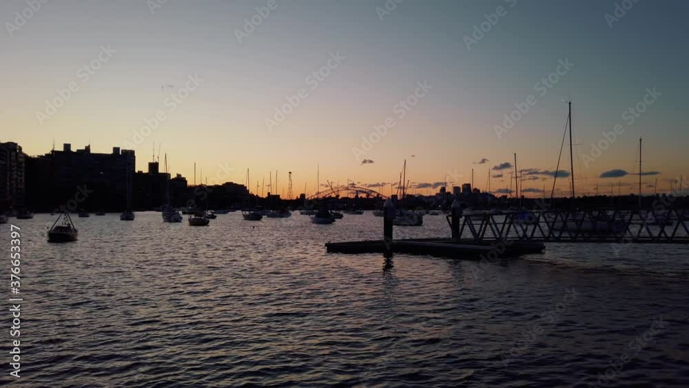 Nighttime at a peaceful harbor with boats floating on surface during sundown Nighttime at a peaceful harbor with boats floating on surface during sundown