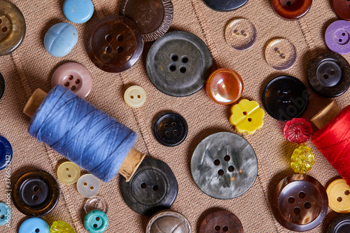 Background and texture of multicolored antique buttons and sewing tools