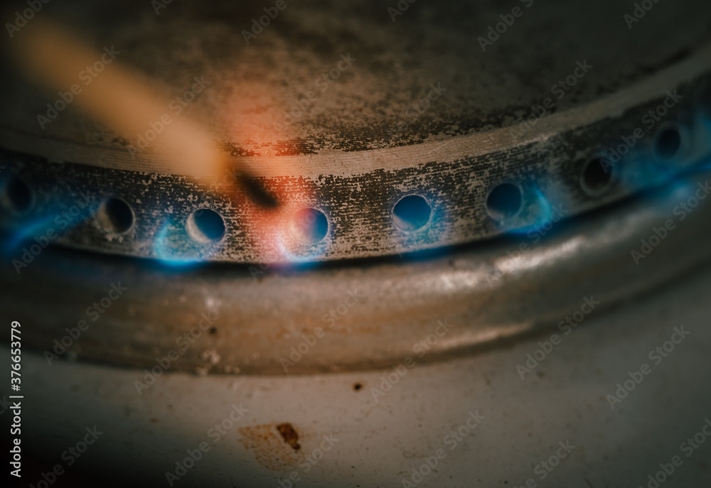 Blue flames of propane burner ignite match. Burner gas stove, concept of energy