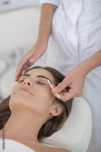 Beautiful woman having procedure of eyebrows dying