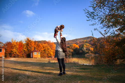Happy family spend fun time together, mother holding the daughter on hand to fly