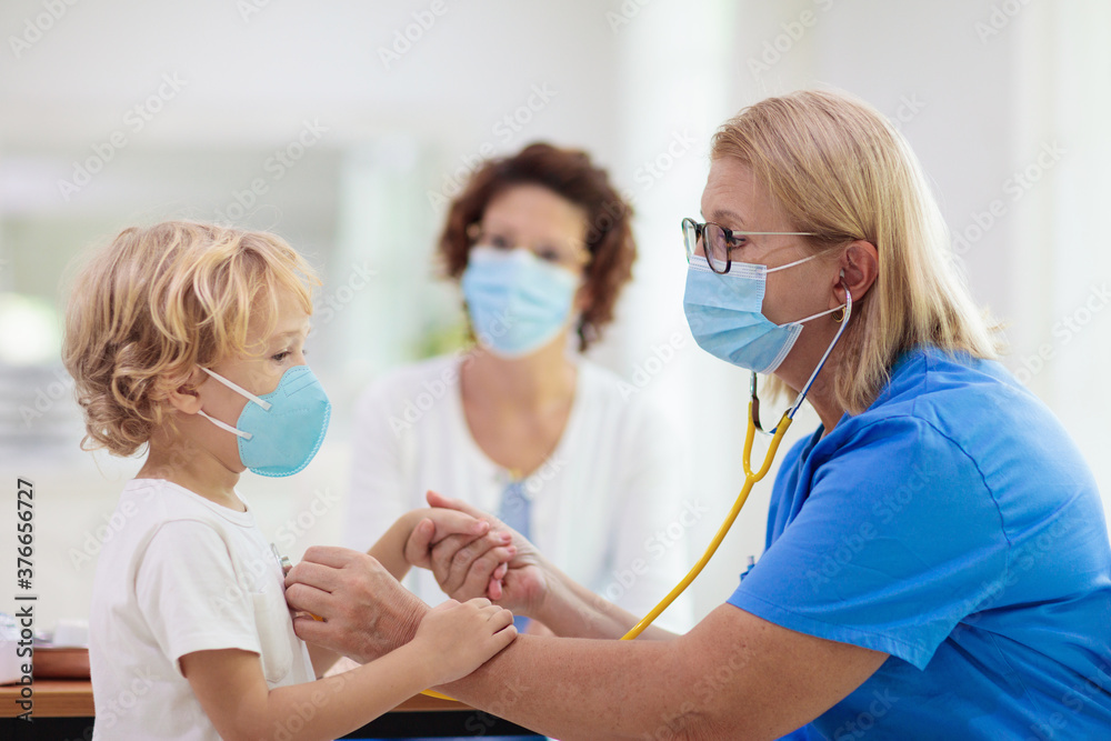 Fototapeta premium Doctor examining sick child in face mask
