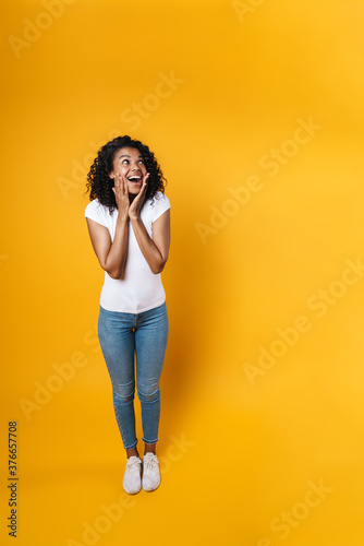 Image of excited african american woman smiling and looking upward