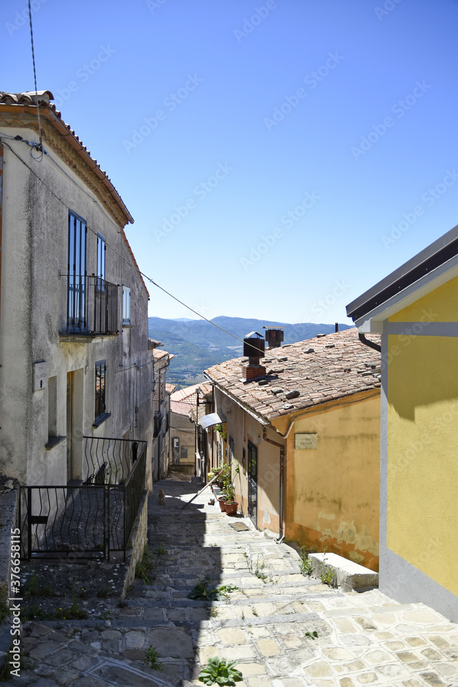 A small road crosses the old buildings of Viggiano, a rural village in the Basilicata region, Italy.
