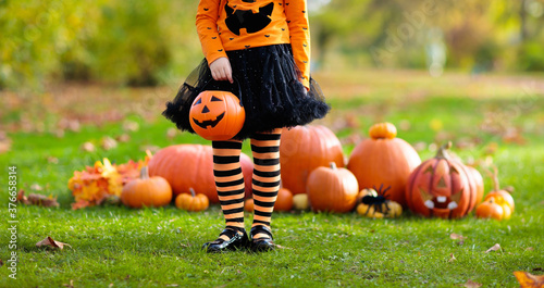 Kids with pumpkins in Halloween costumes