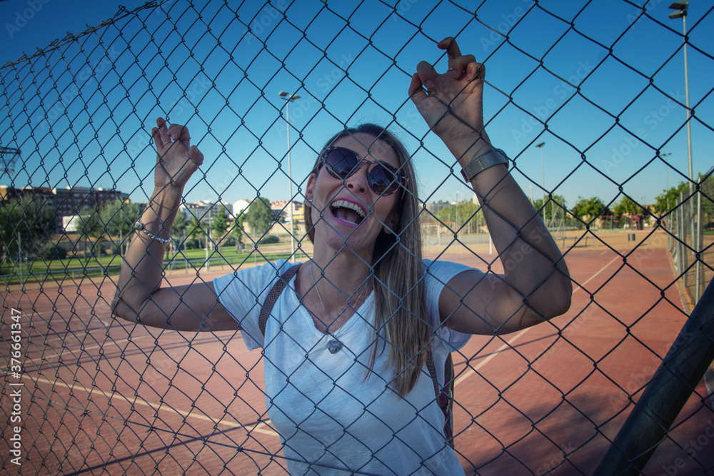 Modern Woman Laughing.
Young woman laughing against basketball fence. Funny woman dressed in white and wearing sunglasses. Lifestyle Modern Woman Laughing.
Young woman laughing against basketball fence. Funny woman dressed in white and wearing sunglasses. Lifestyle