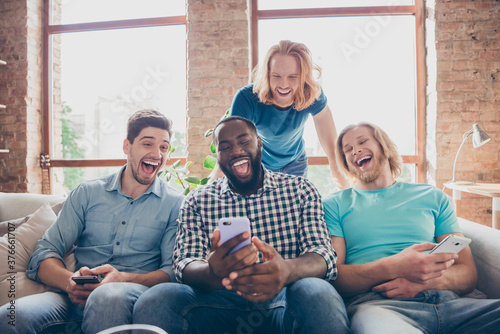 Best pals gathering concept. Afro american guy sit cozy couch use smartphone search social network show buddies funny post enjoy laugh have leisure stay home quarantine time in house indoors