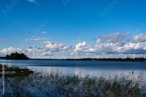 view of a large beautiful lake against the backdrop of clouds and blue sky