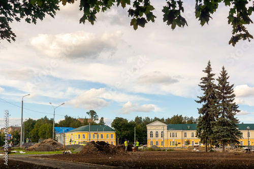 Workers improve the urban environment in historical part of city downtown photo