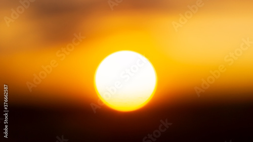 Bright white hot solar ball at sunset in natural background