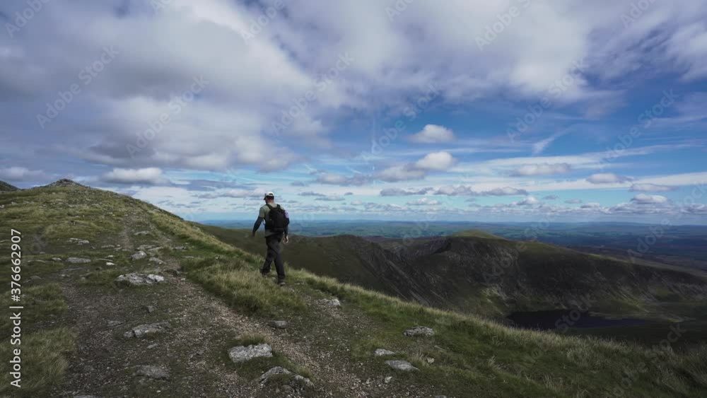 A man walking the Carneddau mountain ridge in Snowdonia A man walking the Carneddau mountain ridge in Snowdonia