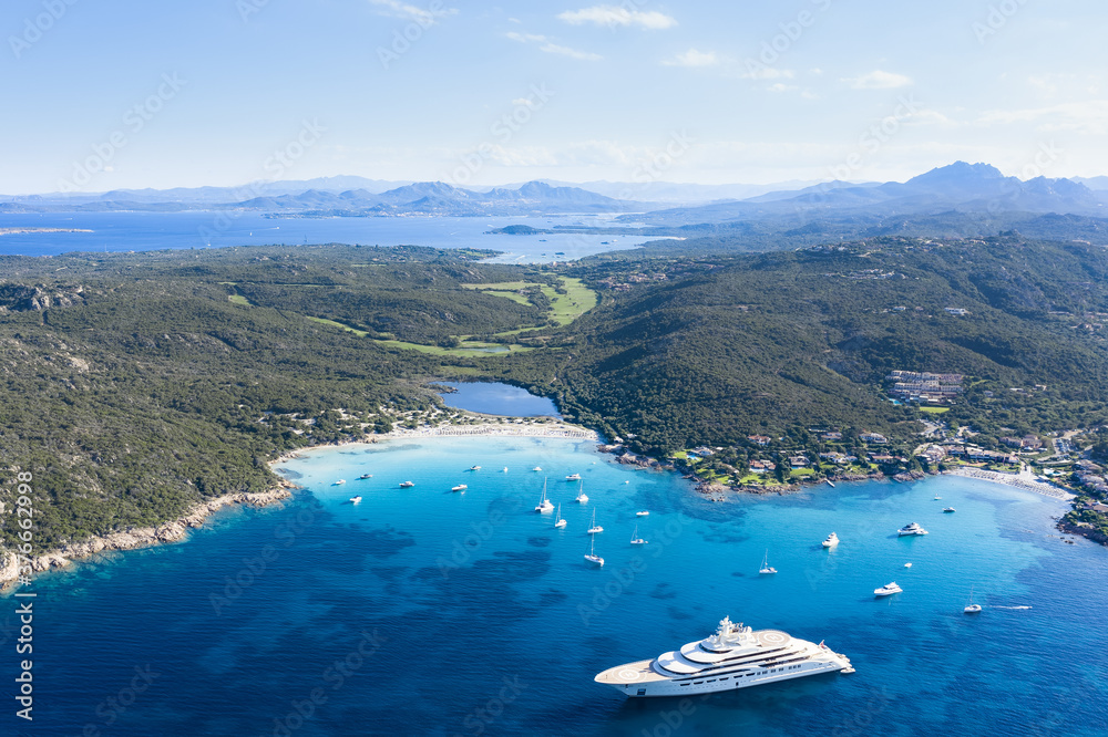 Naklejka premium View from above, stunning aerial view of the Grande Pevero beach with boats and luxury yachts sailing on a turquoise, clear water. Sardinia, Italy.