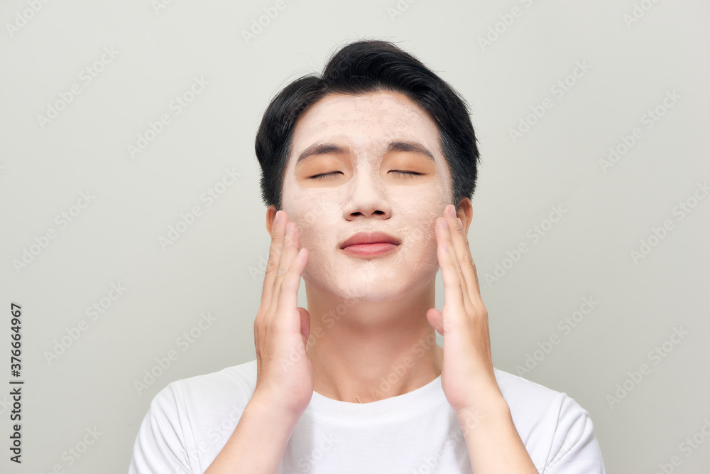 young man with clay mask on face young man with clay mask on face