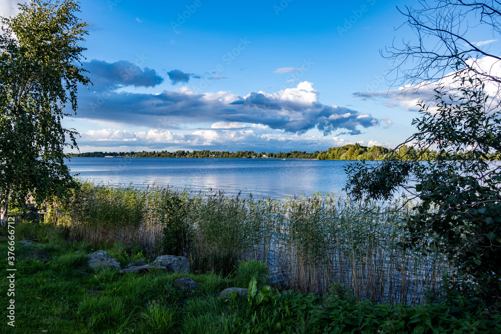 view of a large beautiful lake against the backdrop of clouds and blue sky view of a large beautiful lake against the backdrop of clouds and blue sky