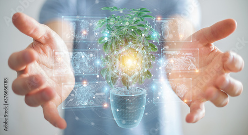 Man holding and touching holographic projection of a plant with digital analysis 3D rendering