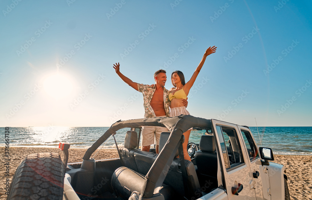 Naklejka premium Couple on beach with car