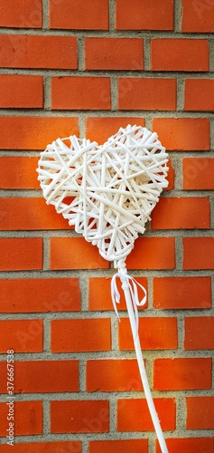 white wicker heart on red brick wall