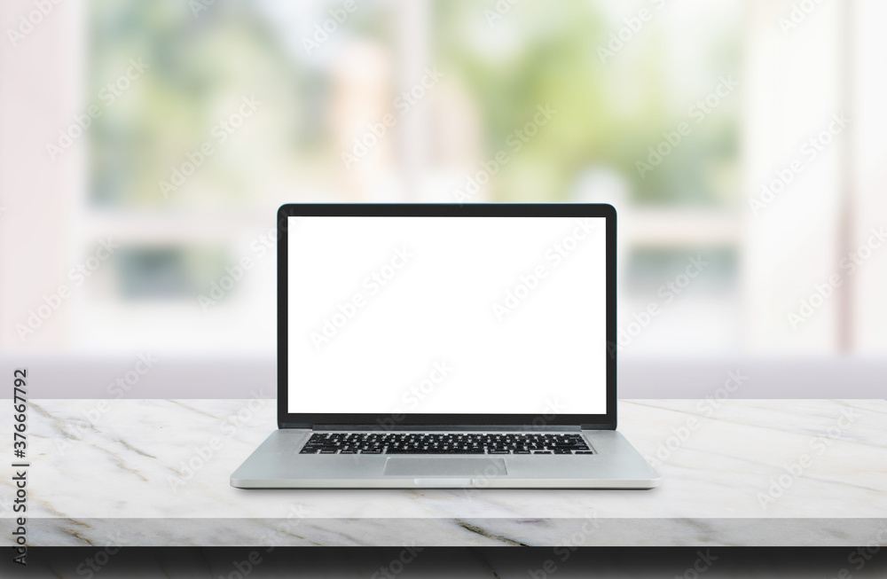 Laptop with white blank screen on marble table top and blurry image of living room in background. Laptop with white blank screen on marble table top and blurry image of living room in background.