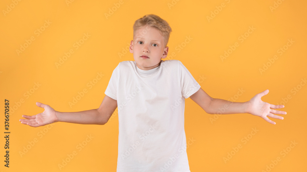 Confused puzzled male kid shrugging at studio Confused puzzled male kid shrugging at studio