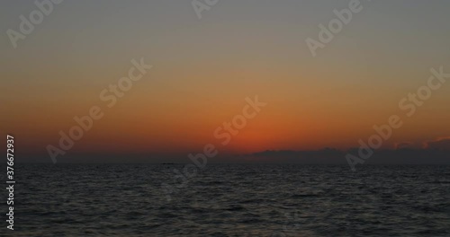 Timelapse 4k, sunset over the sea from Rimigliano beach in San Vincenzo in Tuscany, Italy. photo