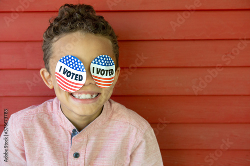 Adorable Mixed Race Boy Wearing I Voted Stickers over Eyes
