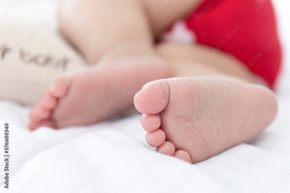 The baby's feet are sleeping in the bed. The baby's feet are sleeping in the bed.