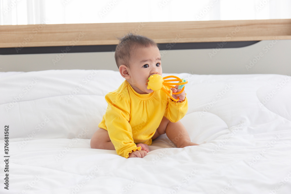 Asian babies are playing baby toys in bed. Asian babies are playing baby toys in bed.