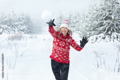 Playful woman throwing a snowball