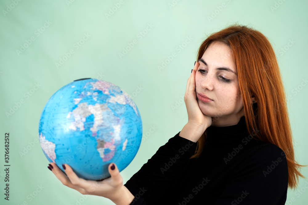 Portrait of a sad worried young woman holding geographic globe of the world in her hands. Travel destination and planet protection concept. Portrait of a sad worried young woman holding geographic globe of the world in her hands. Travel destination and planet protection concept.